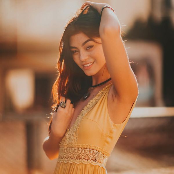 Person smiling and looking energized in a bright, outdoor setting.